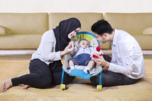 Parents sitting on floor playing with baby